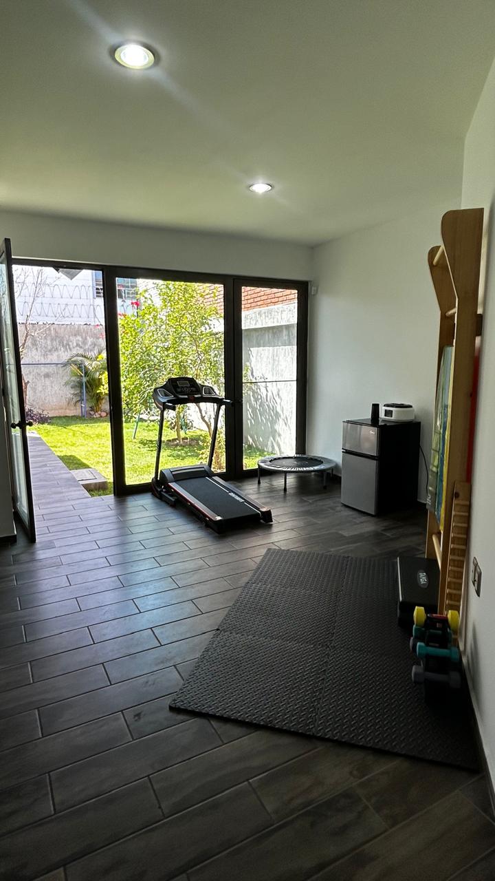 Gimnasio terapéutico con caminadora y área de ejercicio